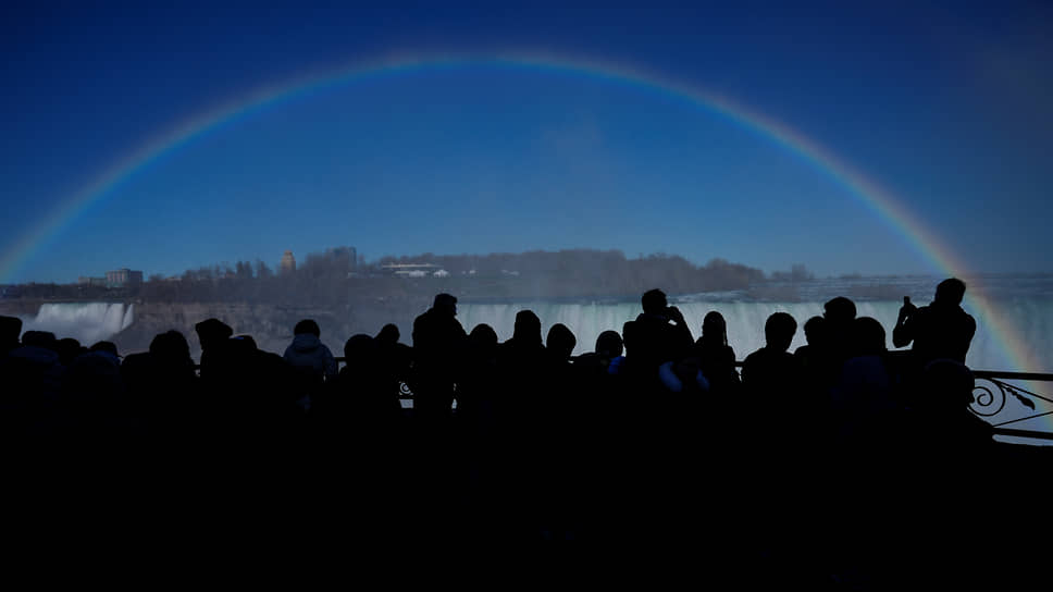Онтарио, Канада. Люди смотрят на радугу над Ниагарским водопадом 
