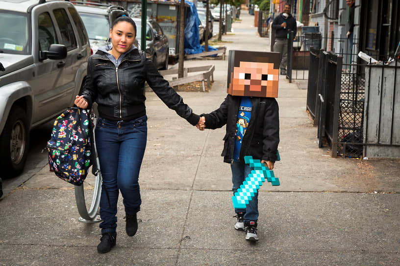 Нью-Йорк, США. Женщина ведет в школу ребенка, одетого в костюм персонажа из игры Minecraft, 2014 год