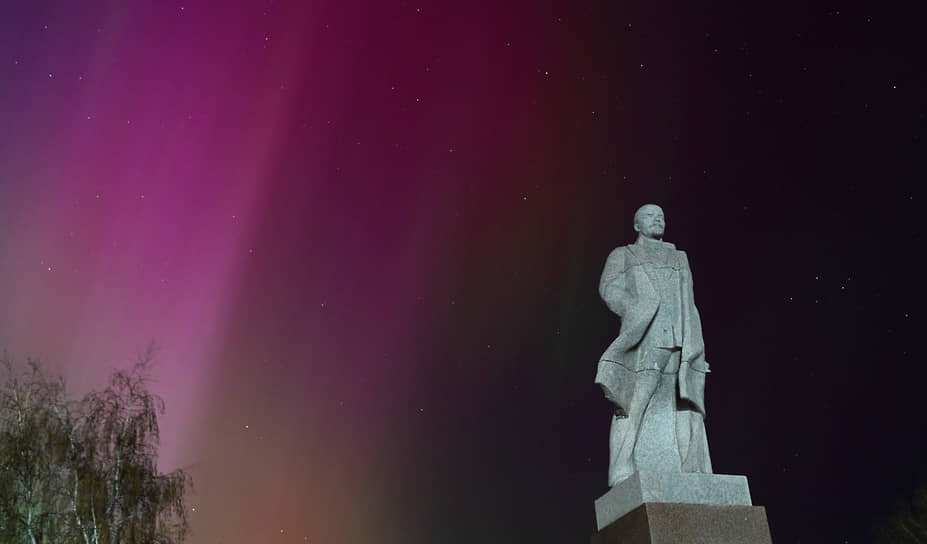 Северное сияние в небе над городом Тара в Омской области на фоне памятника Владимиру Ленину