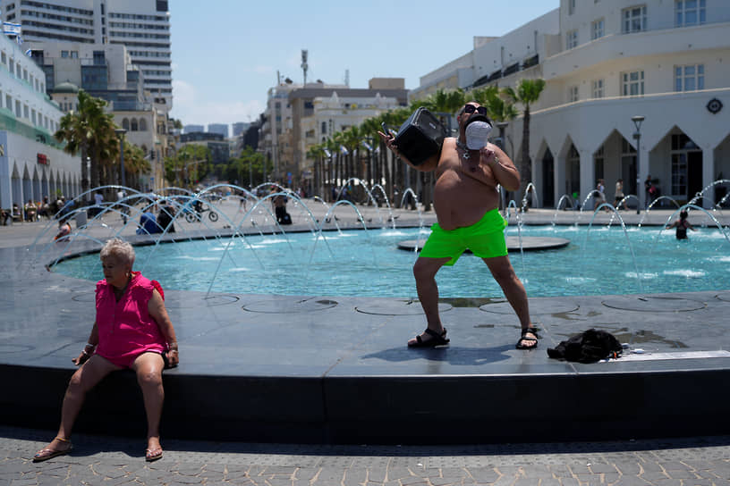 Тель-Авив, Израиль. Мужчина танцует на фонтане во время празднования Дня независимости 