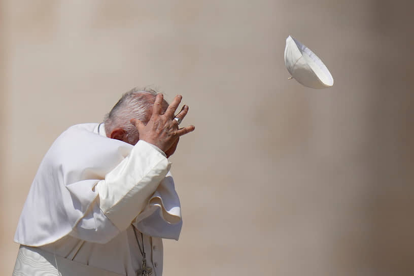 Ватикан. Папа римский Франциск пытается поймать унесенный ветром пилеолус после еженедельной общей аудиенции на площади Святого Петра