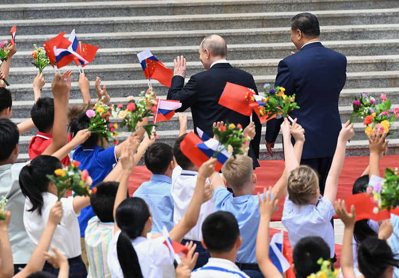 Дети приветствуют председателя КНР Си Цзиньпина (справа) и президента России Владимира Путина 