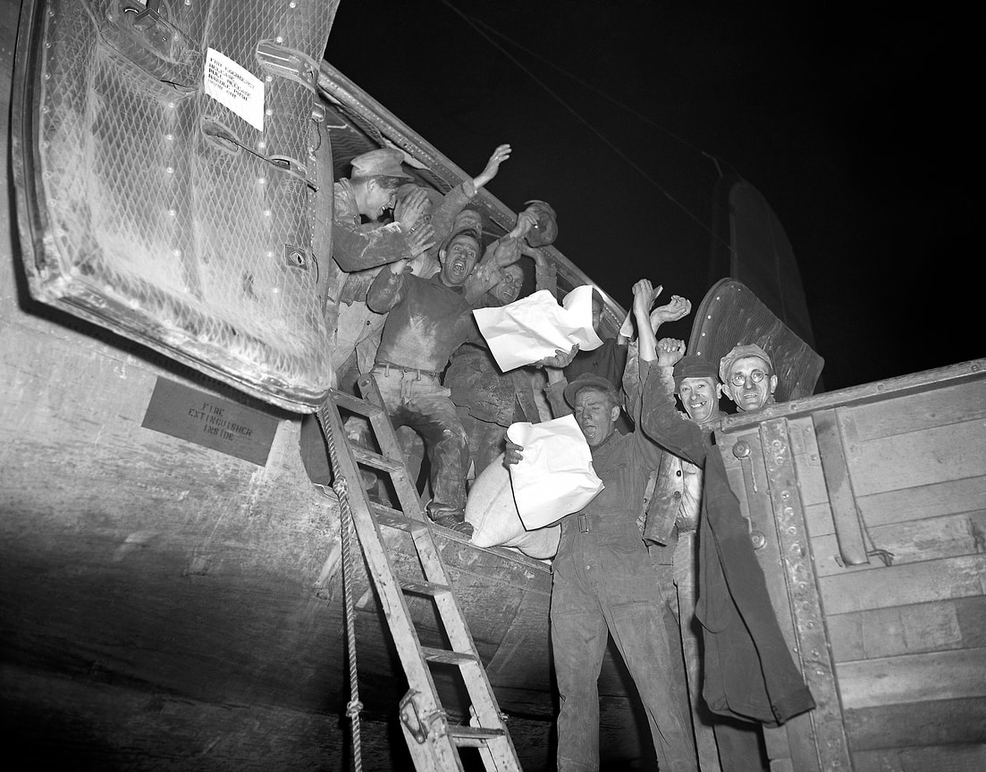 «Все ограничения будут отменены 12 мая 1949 г.» (на фото: грузчики аэродрома Темпельхоф с газетами, сообщающими об отмене транспортных ограничений. Берлин, 5 мая 1949 года)