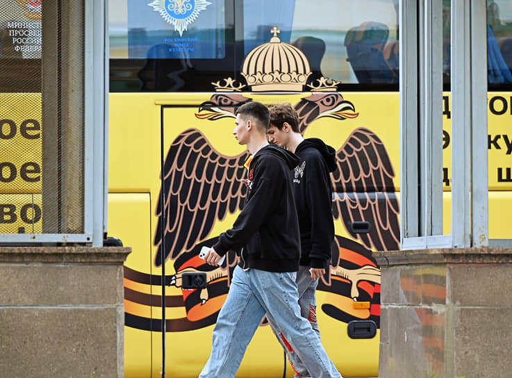 Москва. Прохожие на фоне экскурсионного автобуса с эмблемой Российского военно-исторического общества