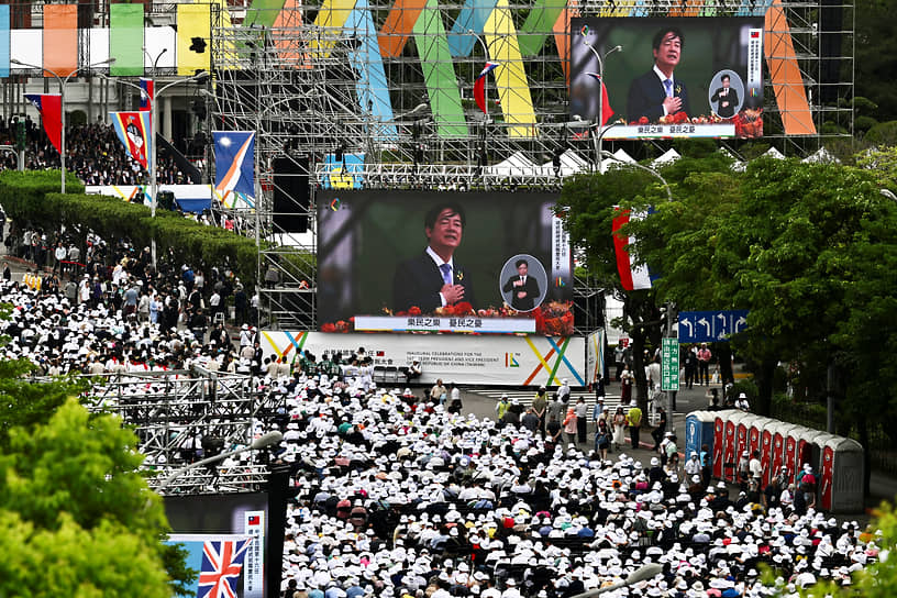 Люди смотрят обращение президента Уильяма Лая на большом экране