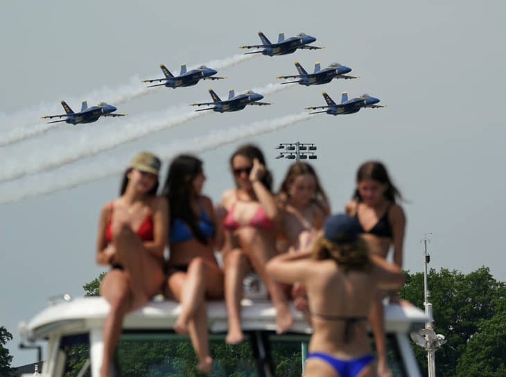 Аннаполис, США. Женщины в купальниках на борту лодки делают групповое фото на фоне вылета демонстрационной эскадрильи ВМС США 