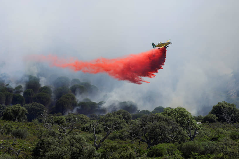 Пуэртольяно, Испания. Самолет сбрасывает огнезащитный порошок на лесной пожар