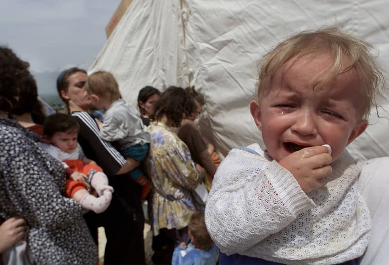 Албанские семьи стоят в очереди у медицинской палатки в лагере для беженцев в македонской деревне Чегране 