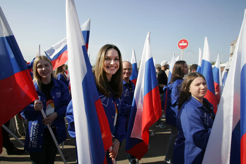 Волонтеры с российскими триколорами готовятся к шествию в Нижнем Новгороде