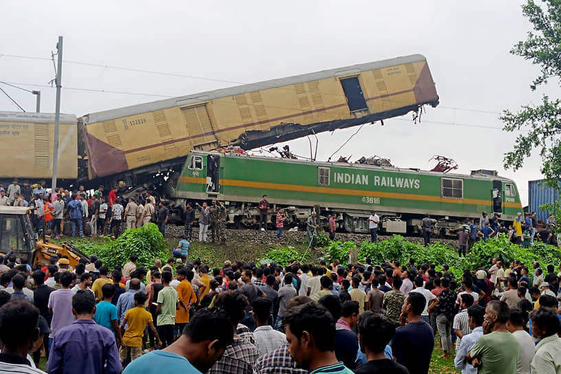 Нью-Джалпайгури, Индия. Люди наблюдают за работой спасателей на месте столкновения двух поездов