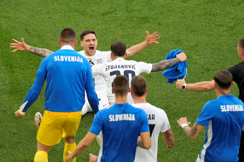 Словенский защитник Эрик Янжа празднует гол, который сравнял счет в матче против Дании