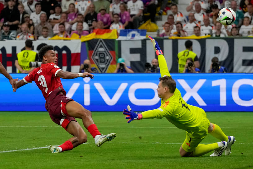 Нападающий сборной Швейцарии Дан Ндойе (слева) атакует ворота Германии