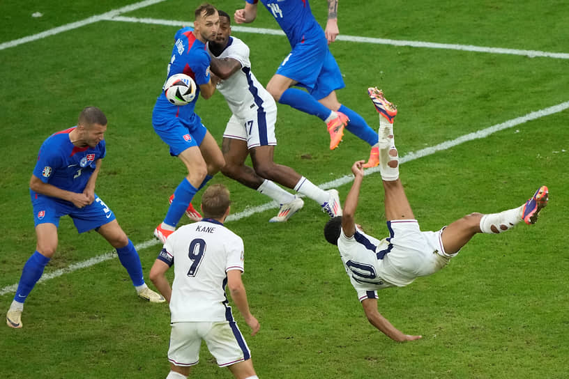 Полузащитник английской команды Джуд Беллингем (справа) забивает мяч в ворота сборной Словакии 
