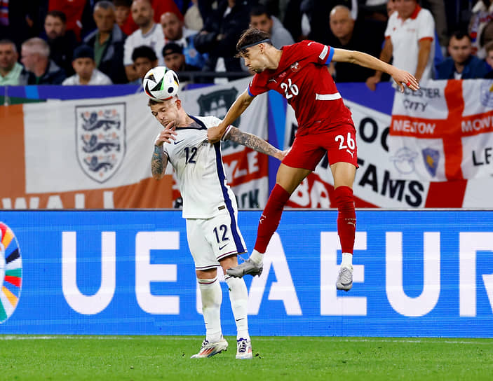 Игрок сборной Англии Киран Триппьер (слева) и серб Велько Бирманчевич борются за мяч