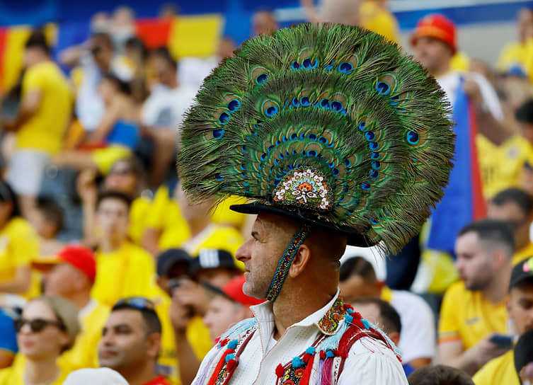 Румынский болельщик в традиционном головном уборе, украшенном павлиньими перьями 