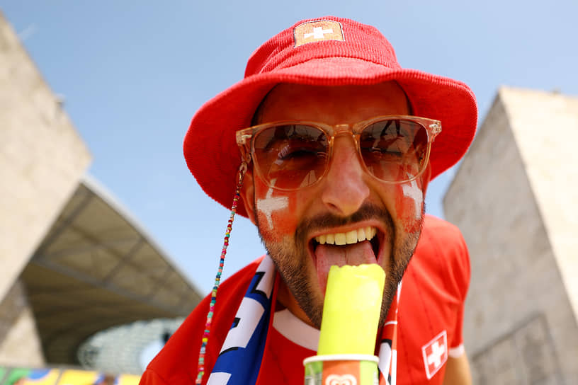 Болельщик из Швейцарии ест мороженое у Олимпийского стадиона в Берлине перед матчем с Италией 