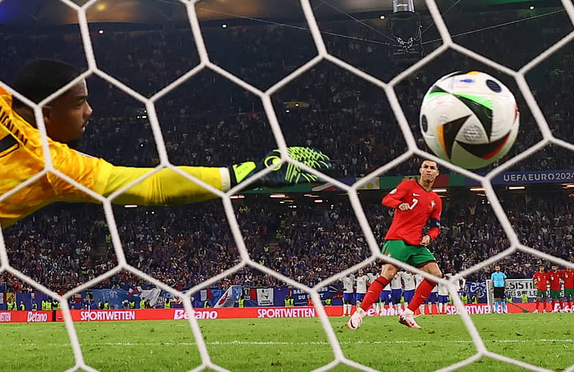 Нападающий сборной Португалии Криштиану Роналдо бьет пенальти в ворота команды Франции 