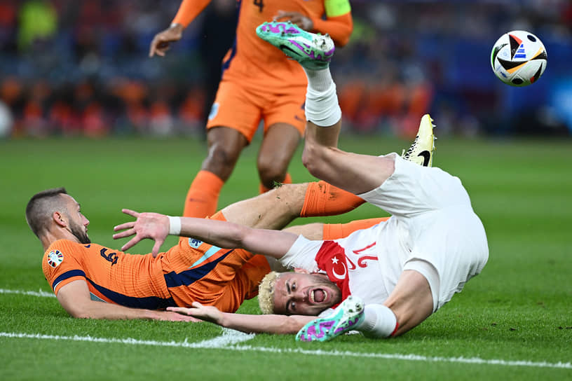 Турецкий нападающий Барыш Йылмаз (справа) после столкновения с футболистами сборной Нидерландов 