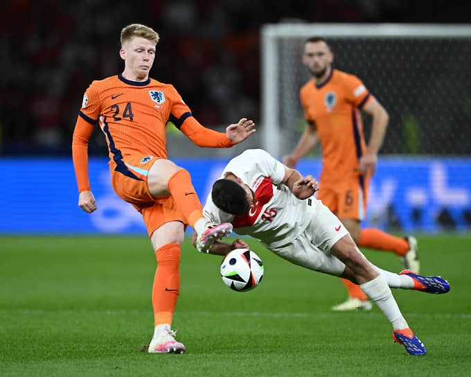 Борьба за мяч между нидерландцем Йерди Схаутеном (слева) и турецким игроком Салихом Озджаном