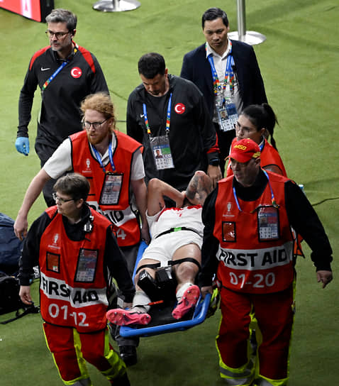 Защитника сборной Турции Самета Акайдына уносят с поля на носилках после столкновения в матче с Нидерландами