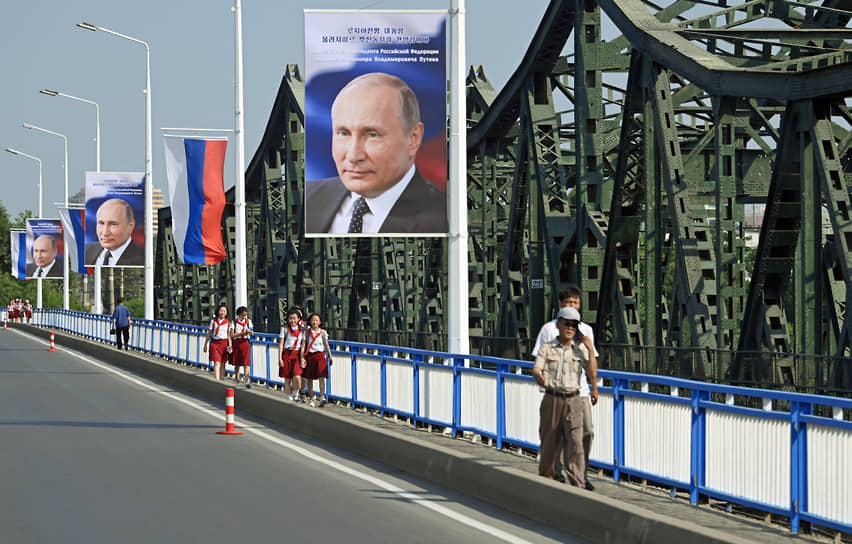 Портреты президента России Владимира Путина и флаги РФ вдоль дороги в Пхеньяне 