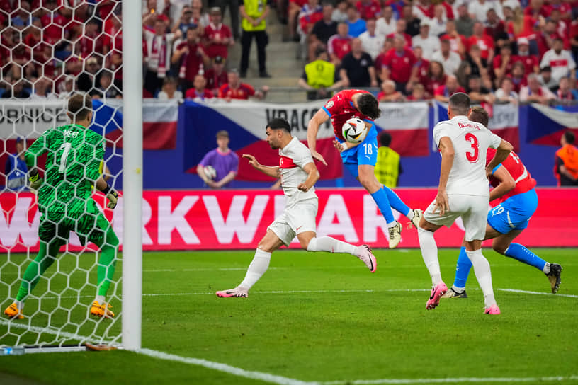 Чешский полузащитник Ладислав Крейчи (в центре) наносит удар головой в ворота турецкого вратаря Мерта Гунока