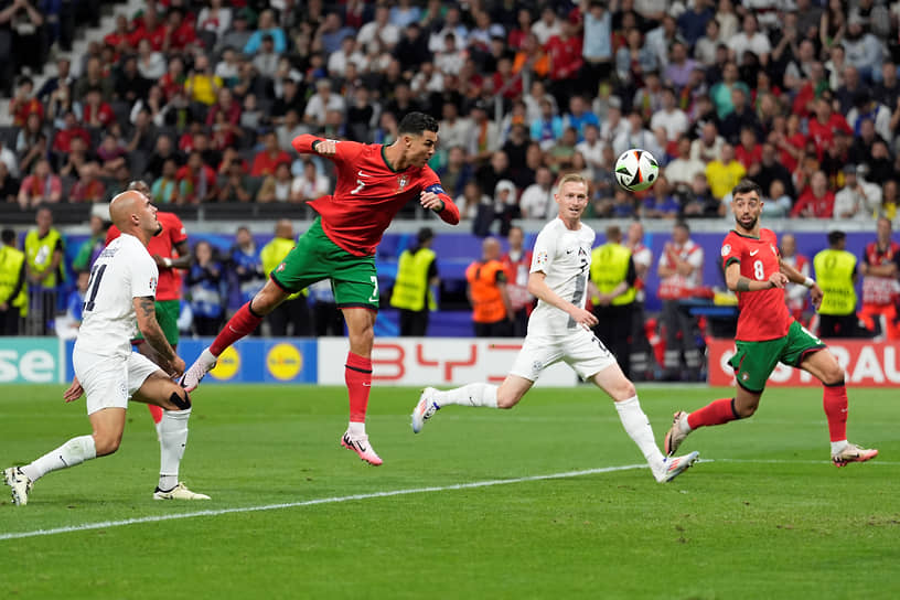 Нападающий сборной Португалии Криштиану Роналду (второй слева) бьет по мячу