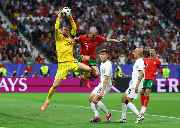 Словенский вратарь Яна Облак (слева) ловит мяч в воздухе