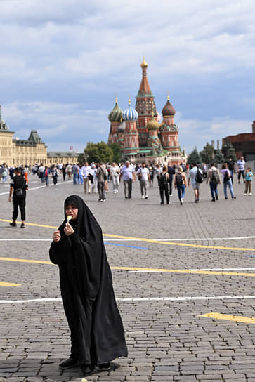 Женщина ест мороженое на Красной площади в Москве
