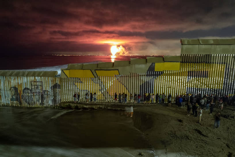 Плайяс-де-Тихуана, Мексика. Мексиканцы на американо-мексиканской границе наблюдают за фейерверком  