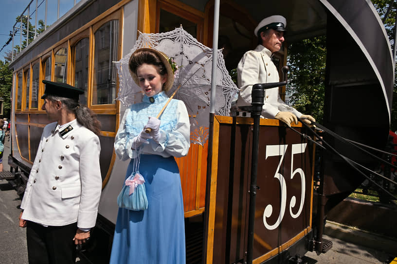 Водители трамвая в исторической форме и пассажирка в старинной одежде перед началом парада