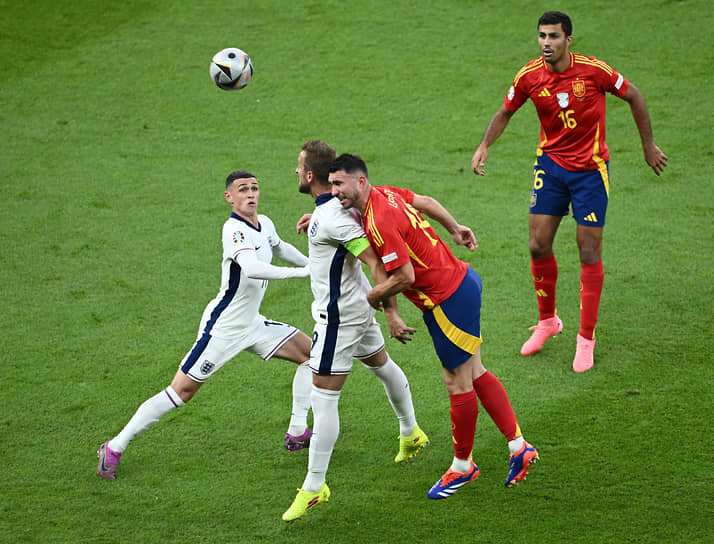 Капитан английской сборной Гарри Кейн (в центре) борется за мяч с испанским защитником Эмериком Ляпортом (второй справа)