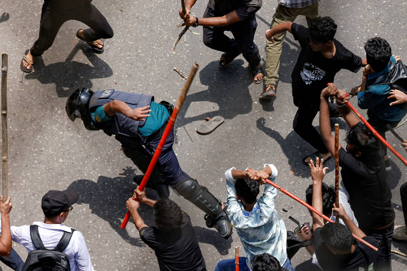 Дакка, Бангладеш. Протестующие студенты избивают полицейского