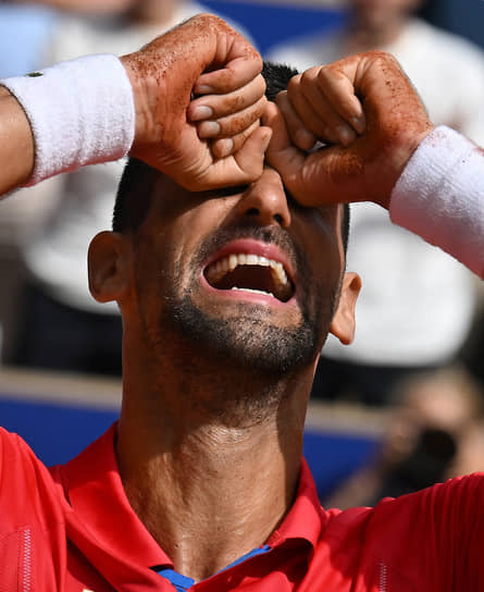 Сербский теннисист Новак Джокович плачет на корте после того, как впервые в карьере завоевал олимпийское золото 