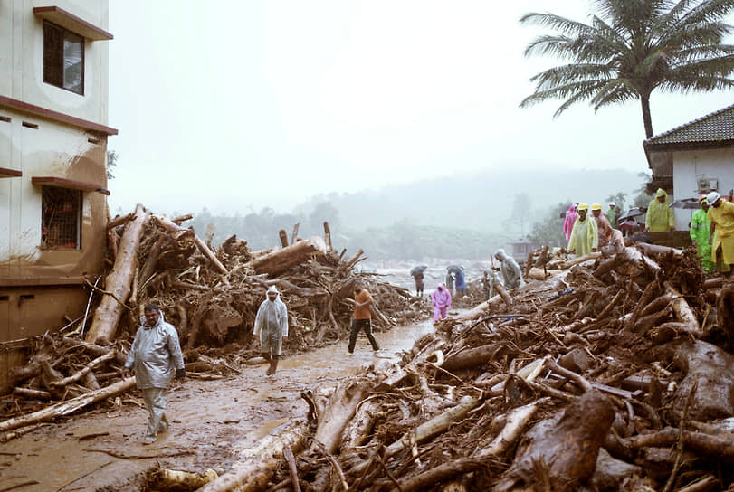 Ваянд, Индия. Прохожие на фоне разрушений, вызванных оползнем