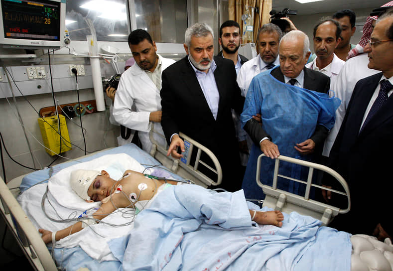 Генеральный секретарь Лиги арабских государств Набиль Эль-Араби (второй справа) и Исмаил Хания (второй слева) рядом с кроватью палестинского мальчика, который, по утверждению палестинских врачей, был ранен в результате израильского авиаудара