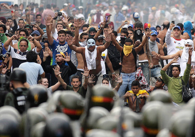 Сторонники Энрике Каприлеса  и представители полиции на демонстрации в Каракасе в 2013 году
