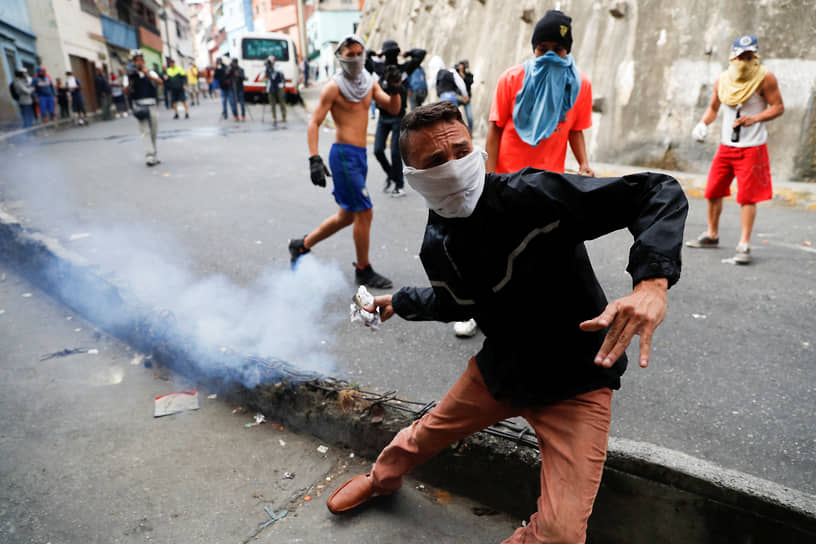 Протестующий в ходе столкновений с силовивками в Каракасе в 2019 году