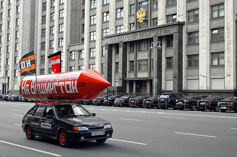 Москва. Автомобиль с бутафорской ракетой с надписью «На Вашингтон, вернуть полетные задания в РВСН РФ» перед зданием Госдумы