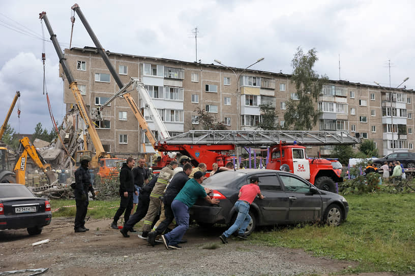 Спасатели МЧС вручную оттаскивали машины, мешавшие технике и людям разбирать перекрытия и другие конструкции дома