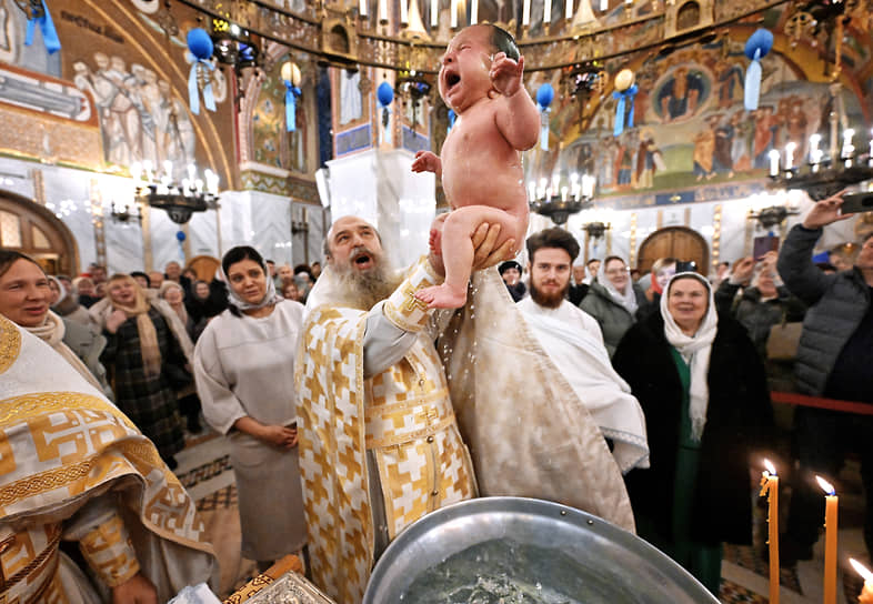 Настоятель храма архимандрит Мелхиседек во время обряда крещения младенца в храме Покрова Пресвятой Богородицы в Москве