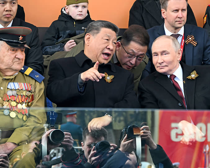 Председатель КНР Си Цзиньпин (в первом ряду в центре) и президент России Владимир Путин (в первом ряду справа) во время парада на Красной площади
