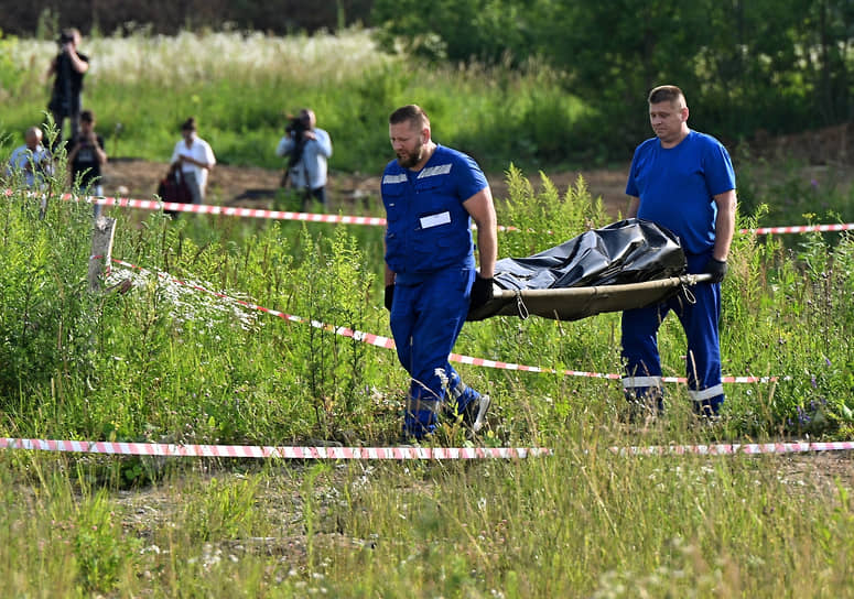 Сотрудники экстренных служб выносят тело погибшего экс-министра Романа Старовойта
