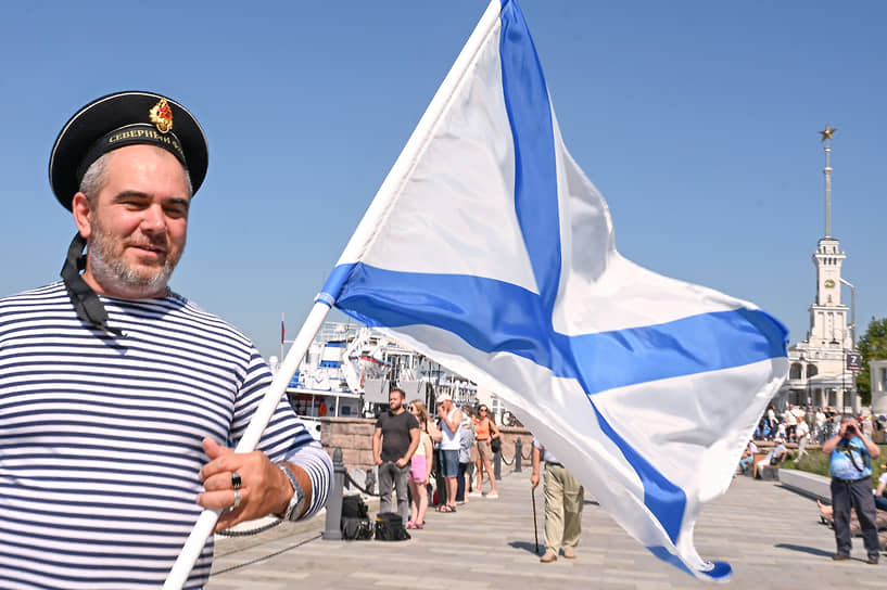 Участник торжеств с военно-морским флагом РФ
