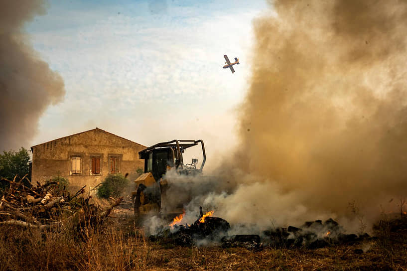 Самолет пролетает над лесным пожаром недалеко от Сен-Лоран-де-ла-Кабрерисс на юге Франции