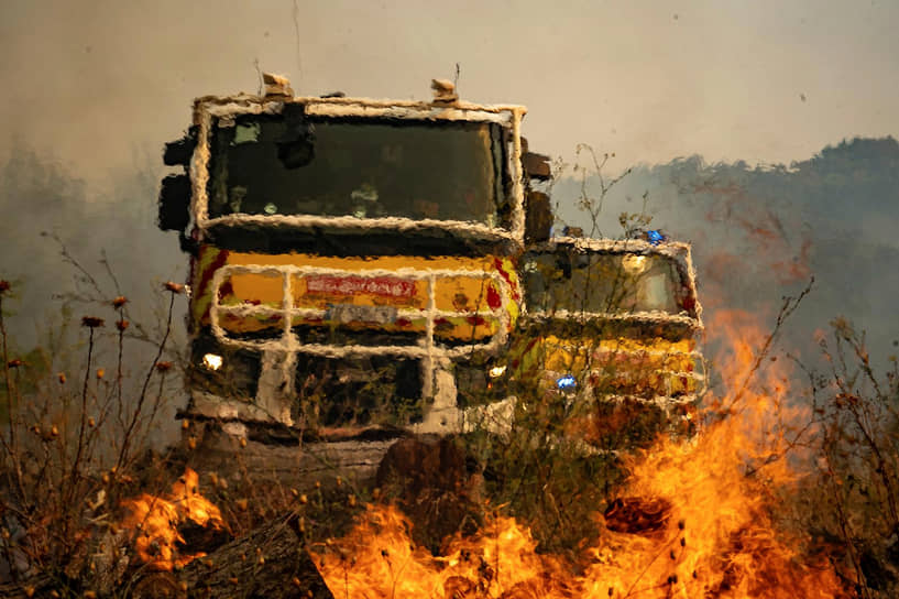 Пожарные машины рядом с горящим лесом
