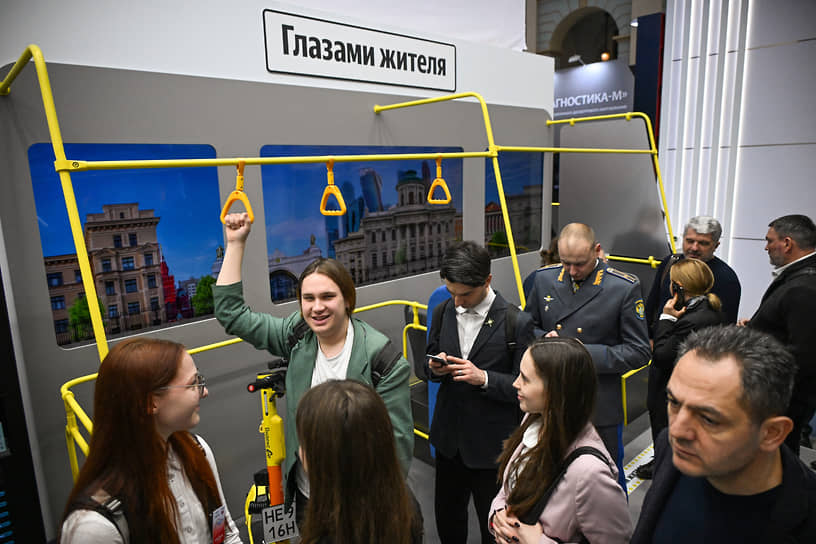 Посетители выставки в макете автобуса