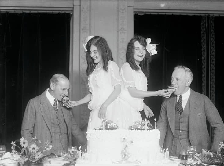 Сросшиеся близнецы Вайолетт (слева) и Дэйзи Хилтон отмечают день рождения в компании шоумена Маркуса Лоу (слева), в шоу которого выступают, и карикатуриста Гарри Хиршфилда