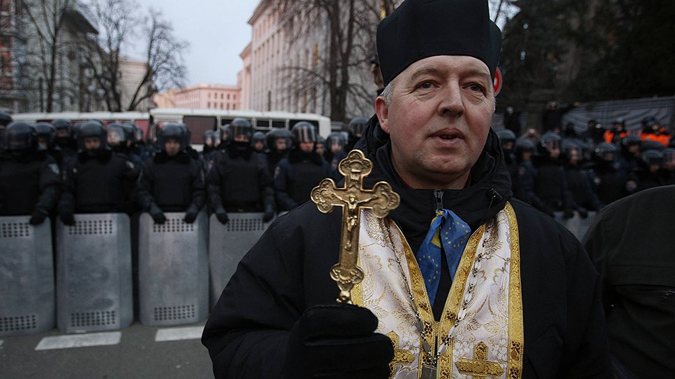 Православный священник проходит мимо кордона &quot;Беркута&quot; возле майдана Незалежности