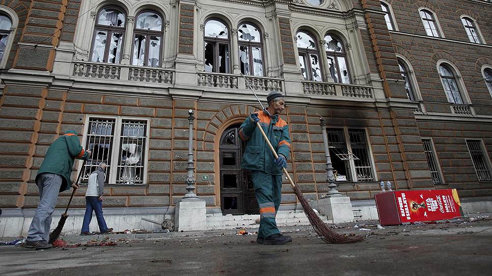 Дворники убирают перед правительственным зданием в Сараево